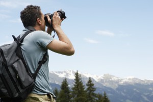 Man Taking Picture in Mountain Landscape
